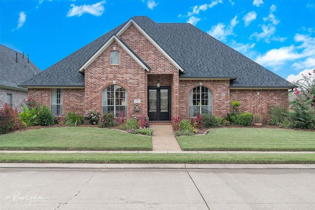 view of front property with a front lawn and french doors