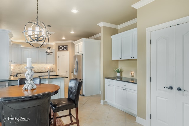 kitchen featuring decorative light fixtures, white cabinetry, crown molding, and light tile patterned flooring