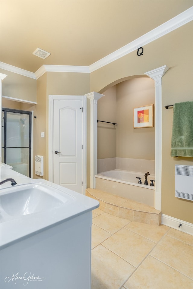 bathroom with ornate columns, ornamental molding, and a tub to relax in