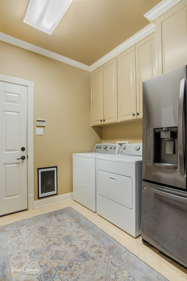 laundry area with washing machine and dryer, light tile patterned flooring, crown molding, and cabinets