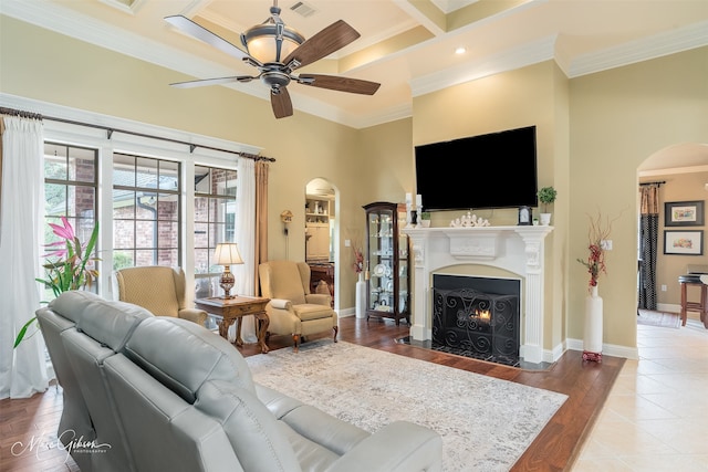 living room with ceiling fan, ornamental molding, and coffered ceiling