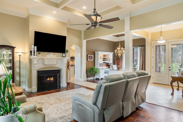 living room featuring coffered ceiling, ceiling fan, crown molding, and hardwood / wood-style floors