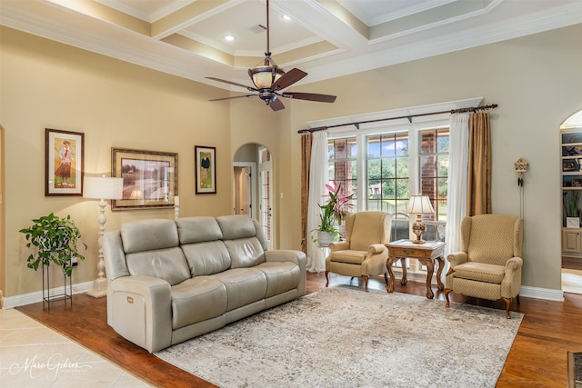 living room featuring ceiling fan, beamed ceiling, crown molding, and coffered ceiling