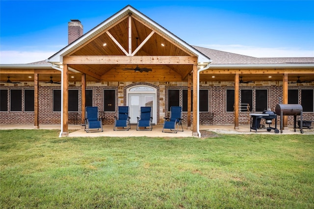 rear view of house featuring a lawn, ceiling fan, and french doors