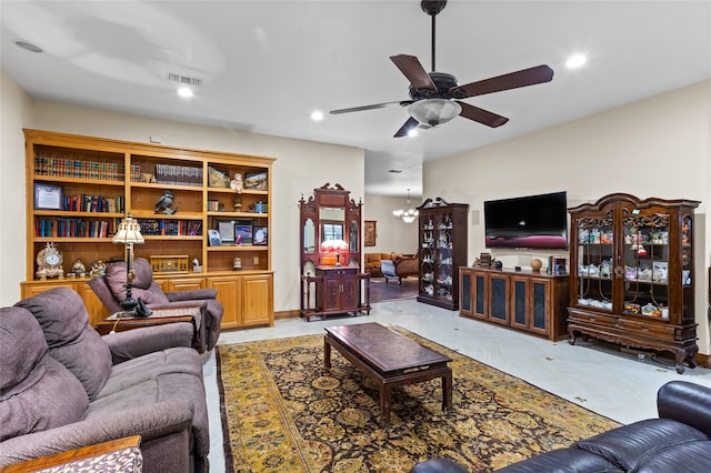 living room featuring ceiling fan with notable chandelier