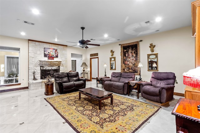 living room with ceiling fan and a fireplace