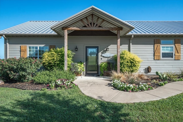 view of exterior entry with a lawn