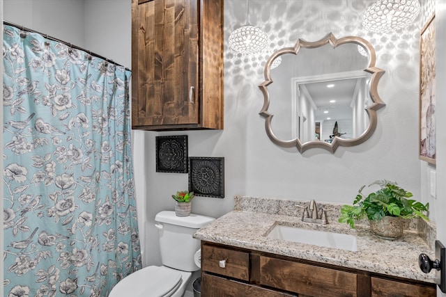 bathroom featuring walk in shower, vanity, and toilet