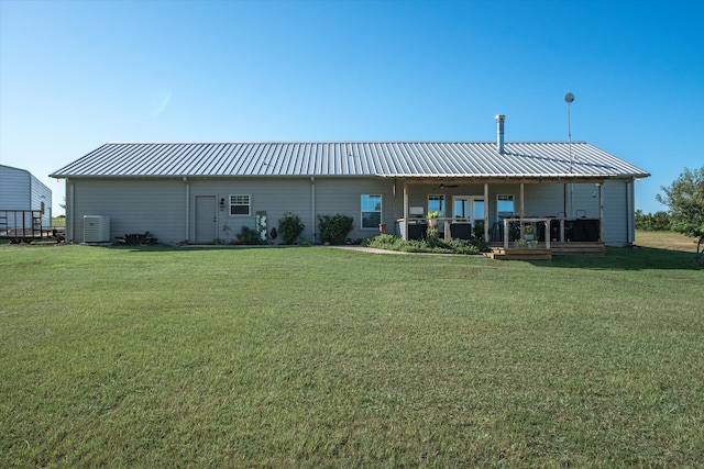 back of house with a lawn, covered porch, and central air condition unit