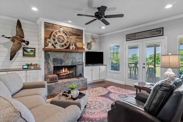 living room with crown molding, a stone fireplace, hardwood / wood-style floors, and ceiling fan