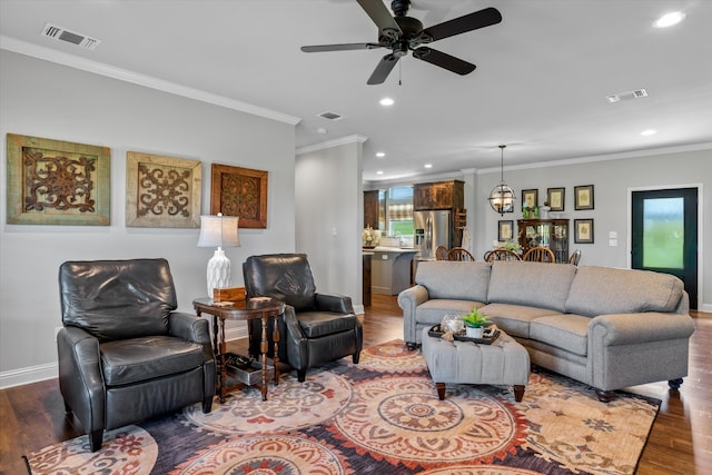 living room featuring ceiling fan, hardwood / wood-style flooring, and crown molding