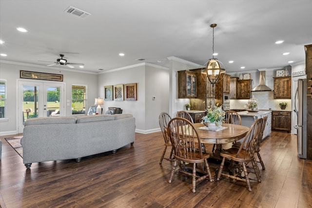 dining area with french doors, ceiling fan with notable chandelier, dark hardwood / wood-style floors, and crown molding