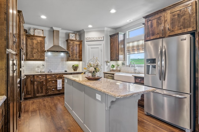 kitchen with light stone counters, dark wood-type flooring, a kitchen island, wall chimney exhaust hood, and black appliances