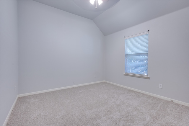 empty room with ceiling fan, lofted ceiling, and light carpet