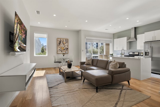 living room featuring light hardwood / wood-style floors and sink