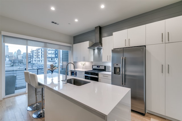 kitchen featuring an island with sink, stainless steel appliances, light hardwood / wood-style floors, and sink