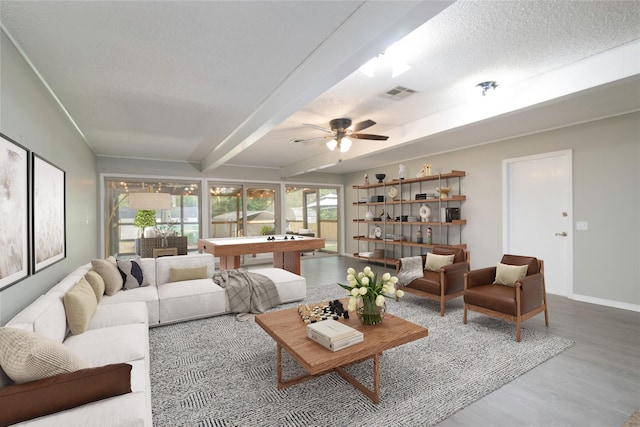 living room with beam ceiling, ceiling fan, wood-type flooring, a textured ceiling, and pool table