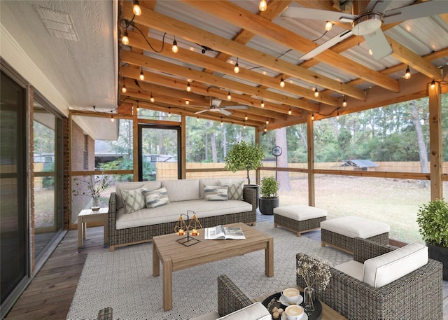 sunroom featuring beamed ceiling and ceiling fan