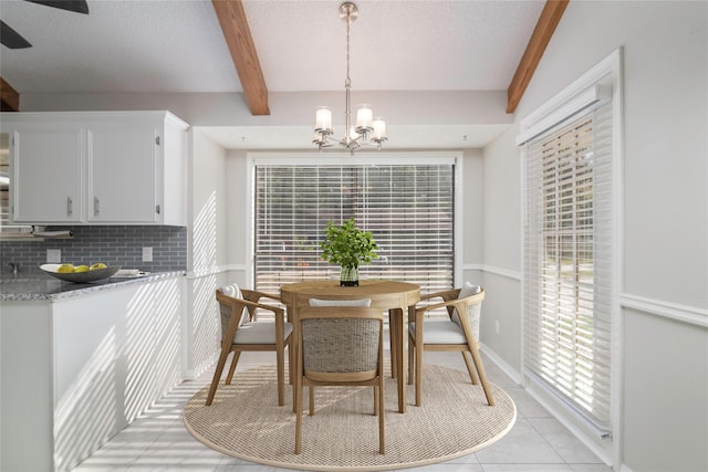 dining space with a notable chandelier, beam ceiling, and light tile patterned floors