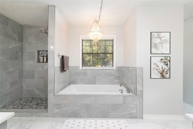 bathroom with a textured ceiling, plus walk in shower, and a chandelier