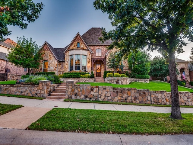 tudor-style house featuring a front lawn