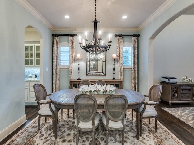 dining room featuring hardwood / wood-style flooring, ornamental molding, and a notable chandelier