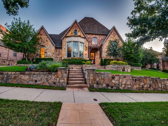 tudor home featuring a yard