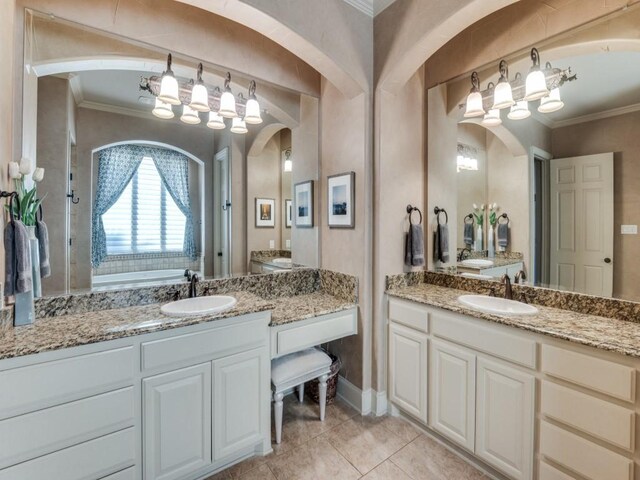 bathroom with tile patterned floors, ornamental molding, vanity, and a washtub