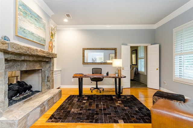 interior space featuring ornamental molding, a fireplace, and light hardwood / wood-style floors