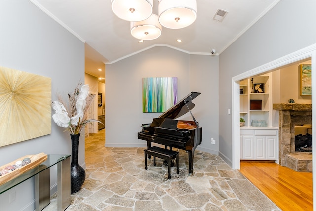 interior space with wood-type flooring, lofted ceiling, a fireplace, and crown molding