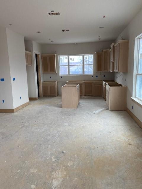 kitchen featuring light brown cabinetry, a kitchen island, and a healthy amount of sunlight