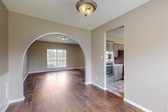 spare room with a textured ceiling and hardwood / wood-style floors