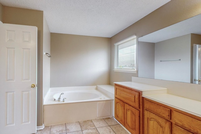 bathroom featuring vanity, a bathtub, a textured ceiling, and tile patterned floors