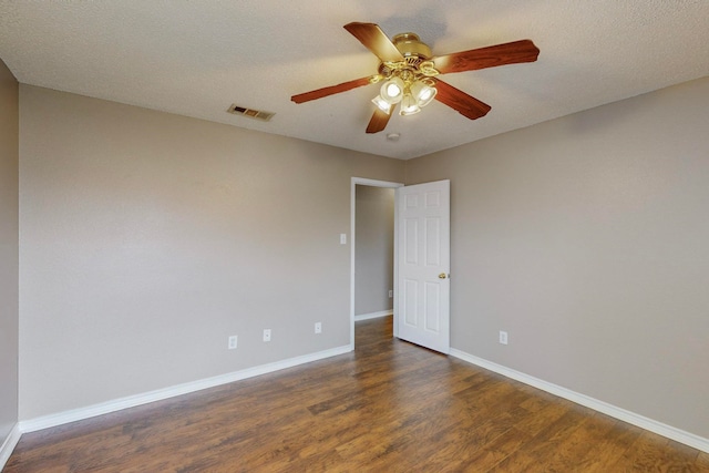 empty room featuring a textured ceiling, dark wood-type flooring, and ceiling fan