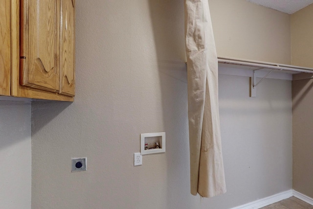 clothes washing area with cabinets, electric dryer hookup, and washer hookup