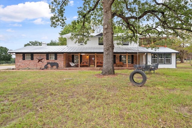 rear view of property featuring a lawn