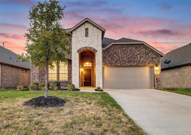 view of front of property with a garage and a lawn