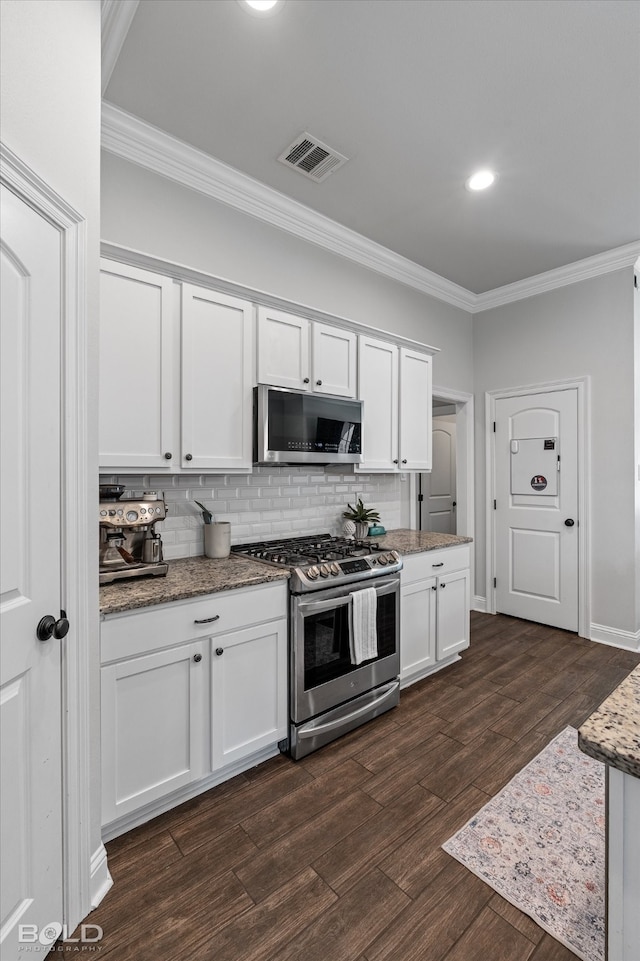 kitchen featuring dark wood-type flooring, stainless steel appliances, and white cabinets