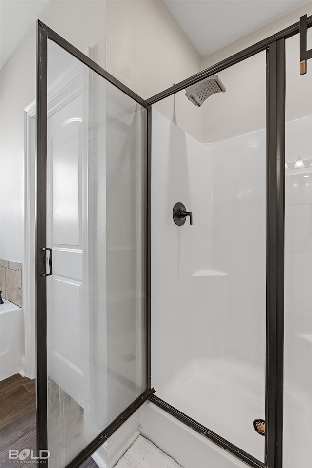 bathroom featuring a shower with door and hardwood / wood-style floors