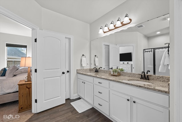 bathroom featuring hardwood / wood-style flooring, walk in shower, and vanity