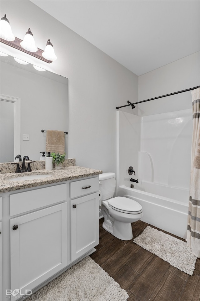 full bathroom featuring hardwood / wood-style floors, vanity, toilet, and shower / bath combo