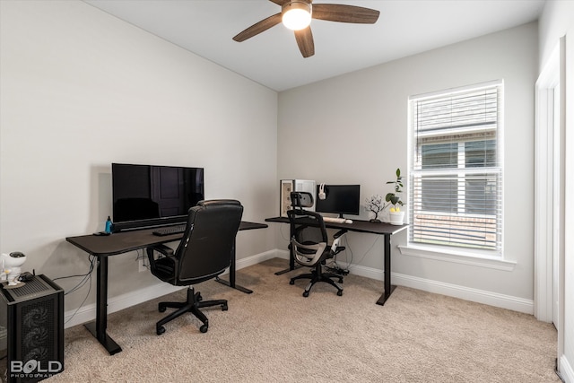 carpeted home office featuring ceiling fan