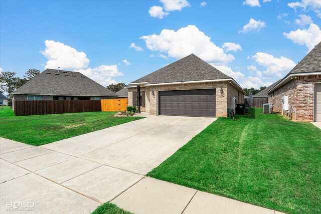 view of front of home featuring a front yard, a garage, and central AC unit