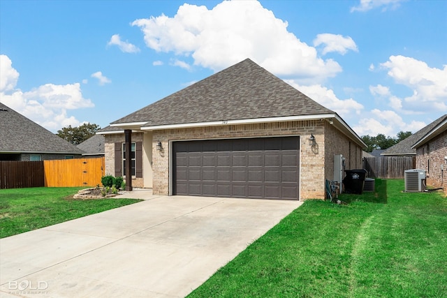 view of front facade with a garage, central AC unit, and a front yard