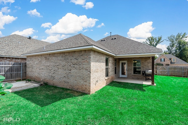 rear view of property with a yard and a patio area