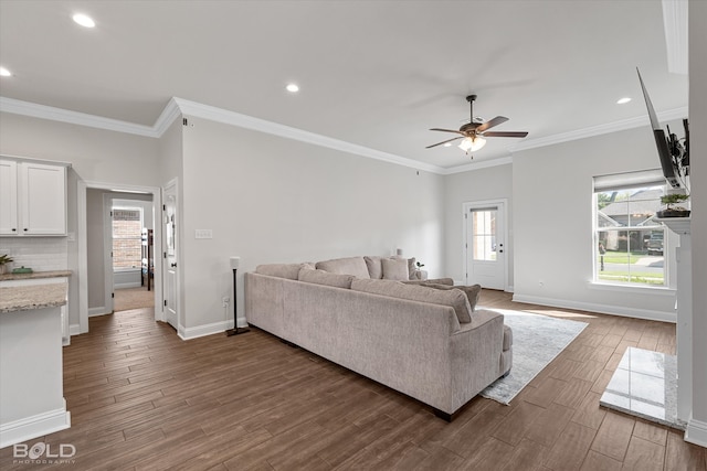 living room with ornamental molding, ceiling fan, and dark hardwood / wood-style floors