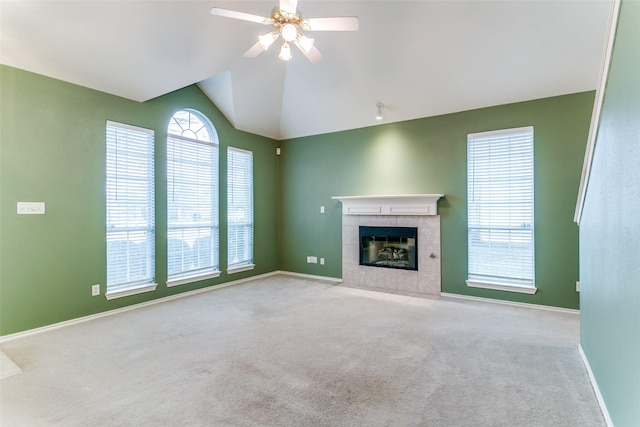 unfurnished living room featuring ceiling fan, lofted ceiling, light carpet, and a tile fireplace