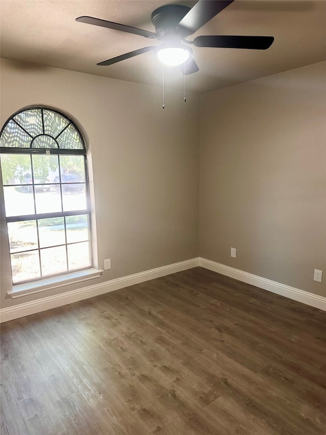 empty room featuring ceiling fan and dark hardwood / wood-style flooring