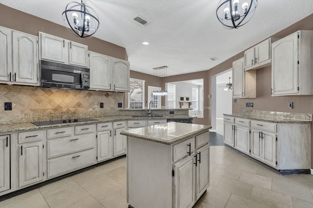 kitchen featuring white cabinets, a center island, and decorative light fixtures