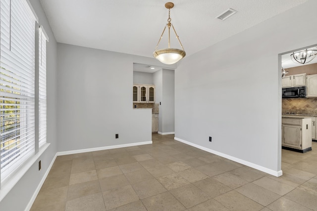 unfurnished dining area with a chandelier